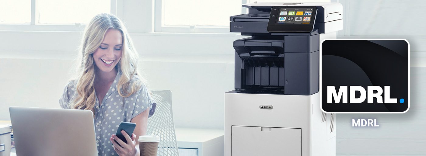 Application My Digital Registered Letter Femme souriante travaille devant ordinateur et téléphone portable à côté d'une imprimante Xerox