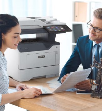 Een man en een vrouw zitten aan een tafel, in gesprek terwijl er een Xerox®-printer in de buurt staat. Een man en een vrouw zitten aan een tafel, in gesprek terwijl er een Xerox®-printer in de buurt staat.