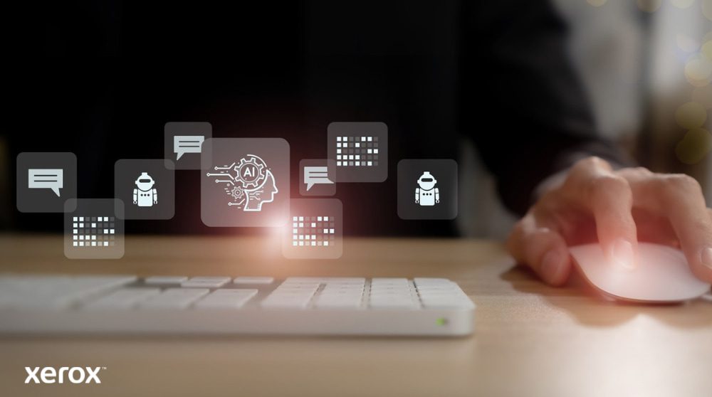 Xerox® DocuShare® Go : gestion intelligente des documents La main d'une personne est posée sur une souris d'ordinateur, avec des icônes lumineuses abstraites liées à la communication, à l'IA et au traitement des données flottant au-dessus du clavier, représentant des fonctionnalités de documents intelligents.